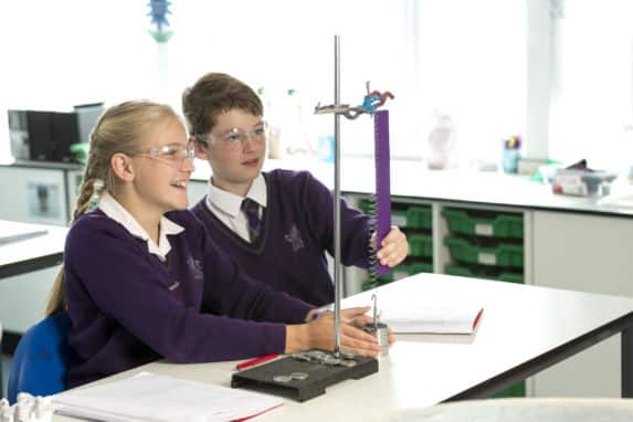 prep school boy and girl participating in physics experiment