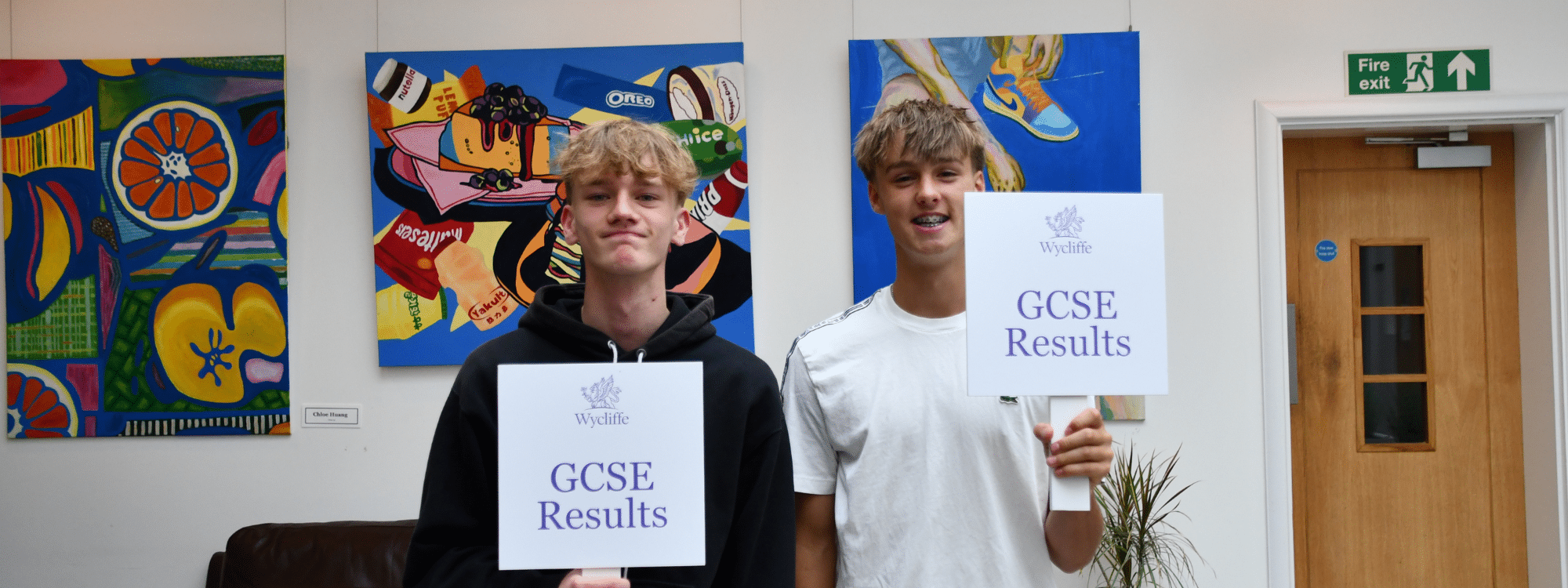 Senior school boys holding up their GCSE results