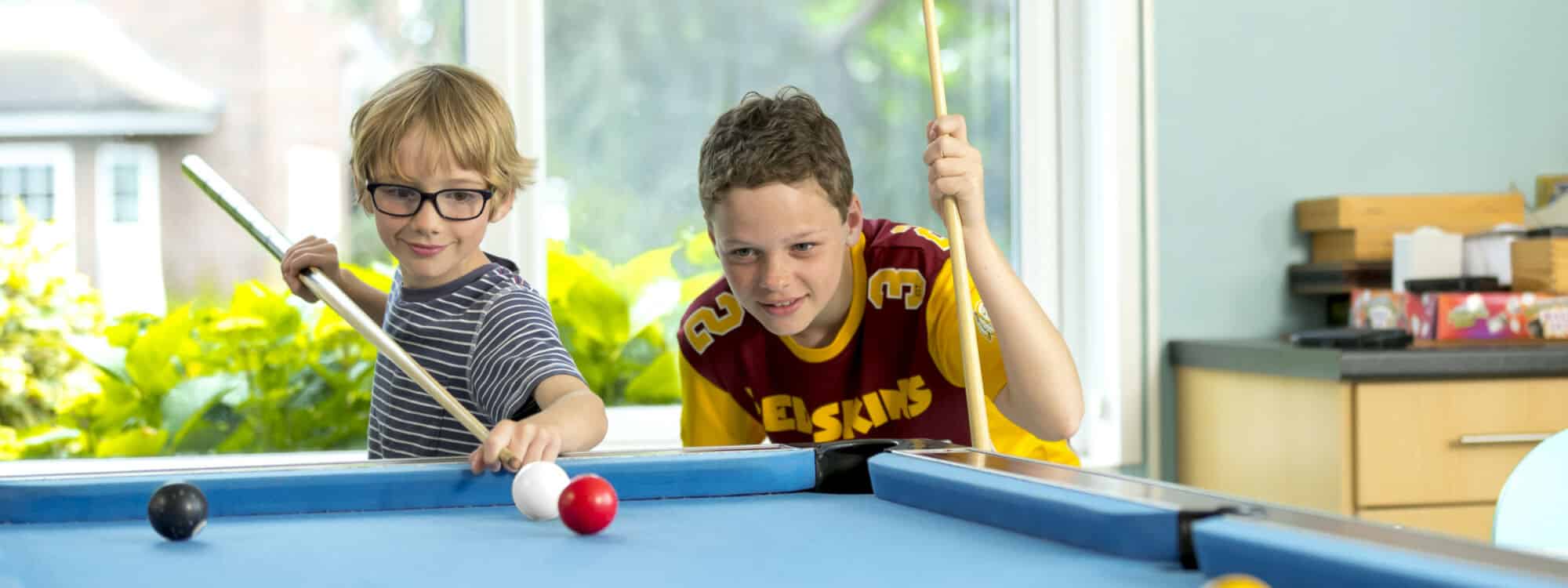 Two school boys playing pool