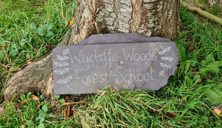 Sign with text 'Wycliffe Woods Forest School'