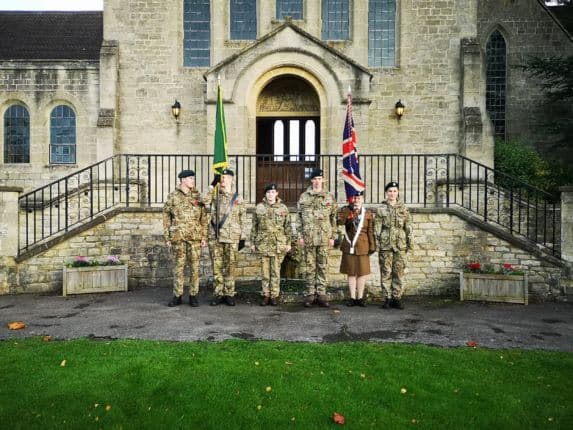 School pupils in military uniform standing in row outside chapel building