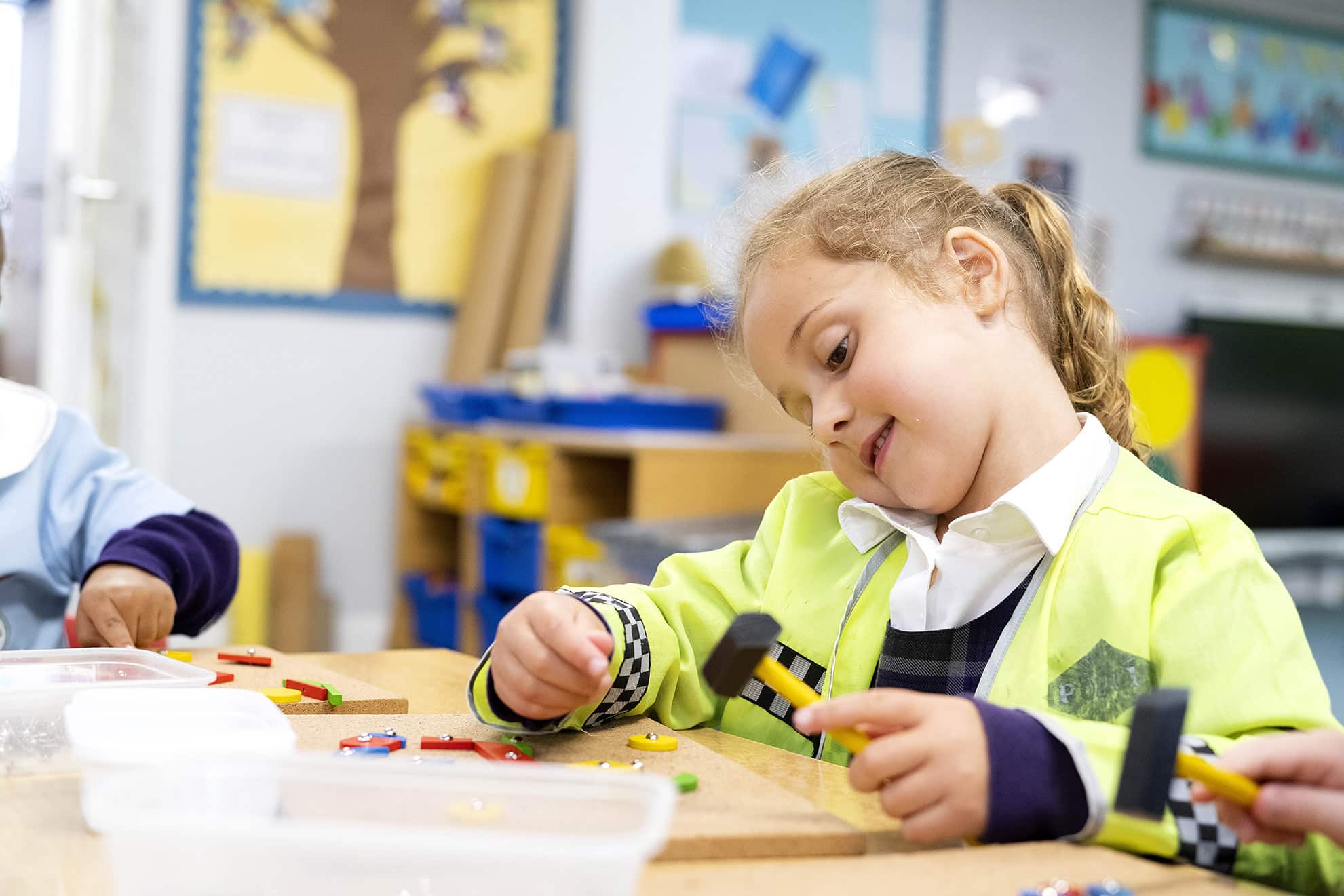 Nursery school girl in police costume playing with xylophone