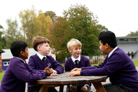 School boys sat around picnic table