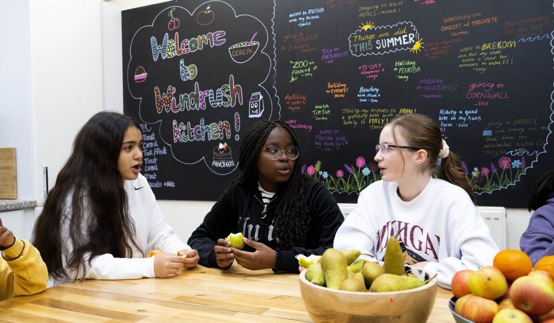 Three school girls sat around table