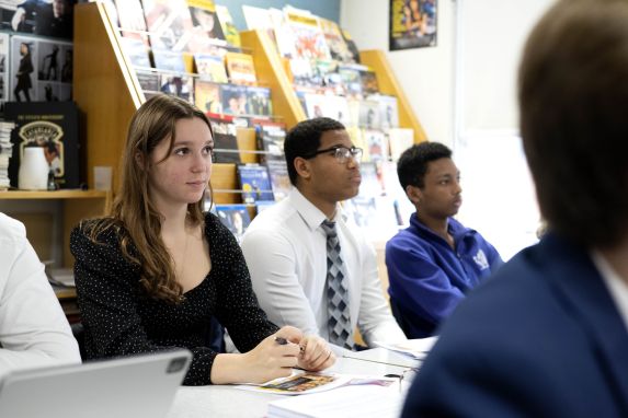 School children in classroom paying attention, with girl in focus