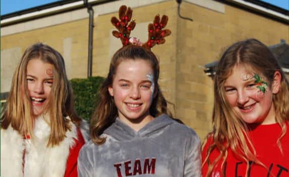 Three school girls wearing Christmas clothing and face paint