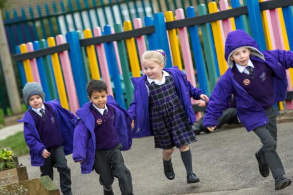 Group of pre prep and nursery children running in playground