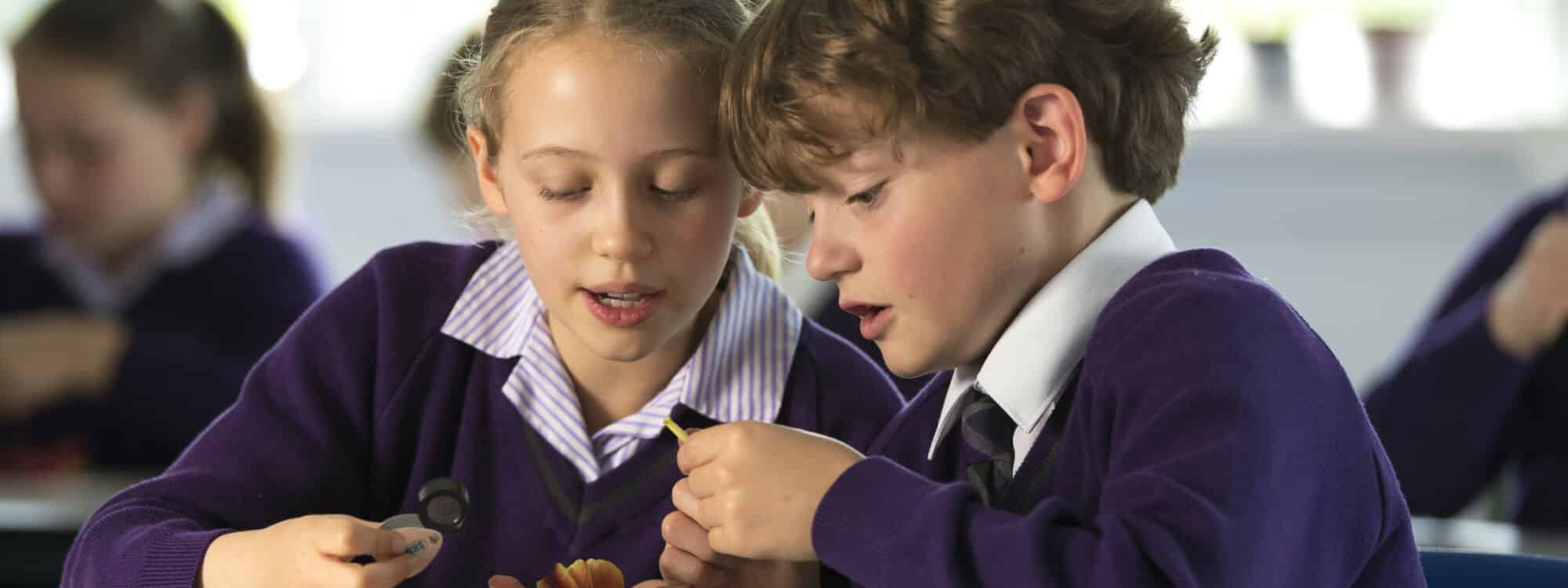 prep school girl and boy observing object