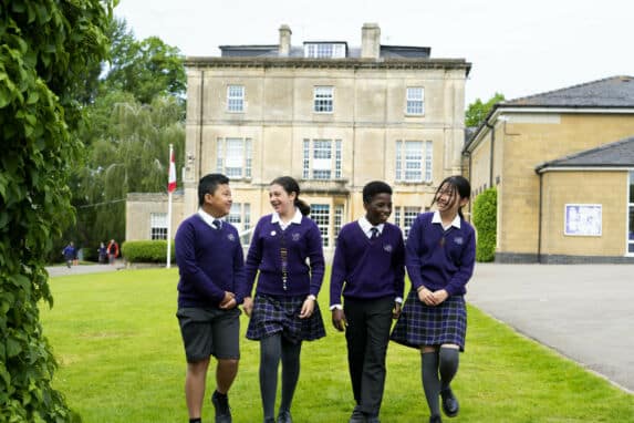 Two boy and two girl school pupils walking together outdoors