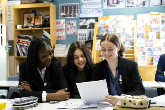 Three school girls reviewing worksheet