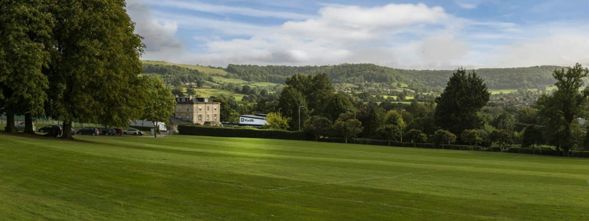 Beautiful green school grounds with Cotswold hills in the background