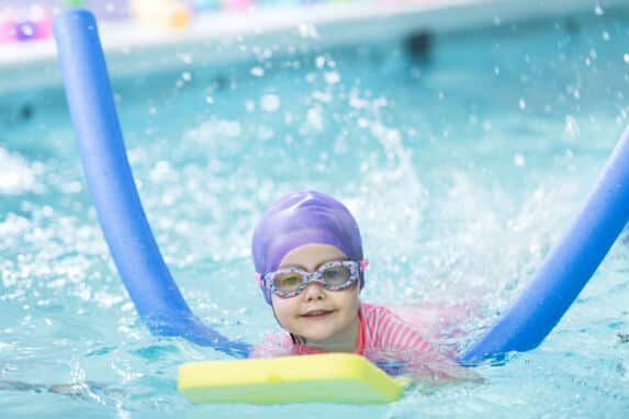 pre-prep girl swimming with foam noodle aid