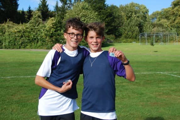 Two boys in school field with arms around each other