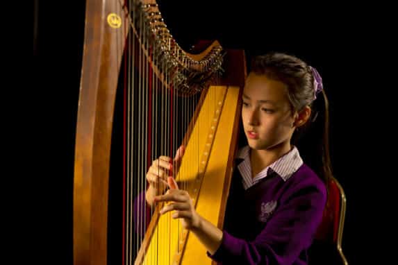 School girl playing harp