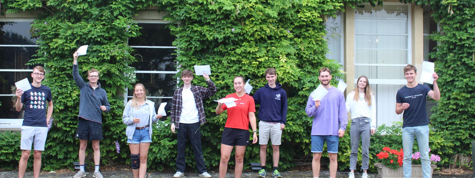 Group of senior school pupils holding results papers